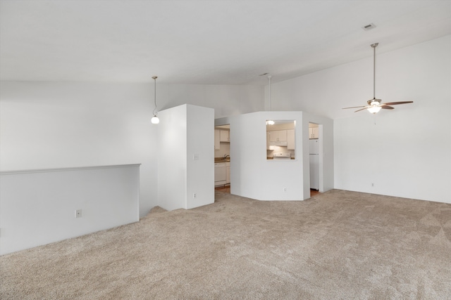 unfurnished living room featuring ceiling fan, carpet, and vaulted ceiling