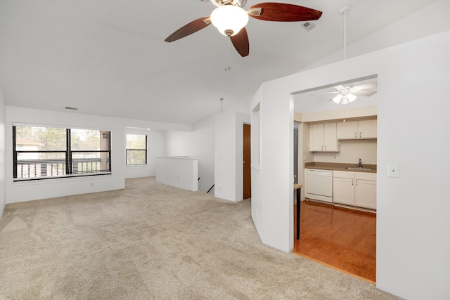 unfurnished living room with a sink, ceiling fan, and vaulted ceiling