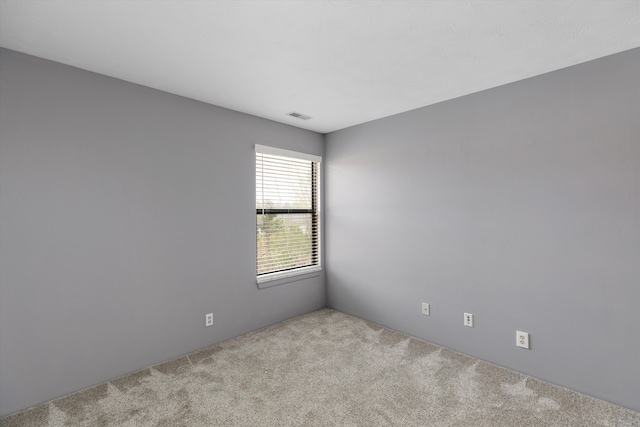 empty room featuring visible vents and carpet