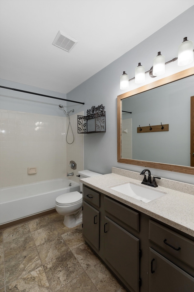 bathroom featuring visible vents, vanity, toilet, shower / bath combination, and stone finish flooring