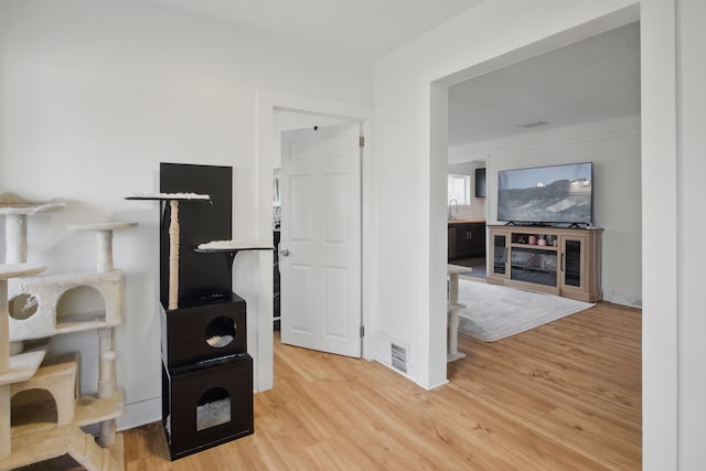 interior space with a sink, light wood finished floors, and visible vents