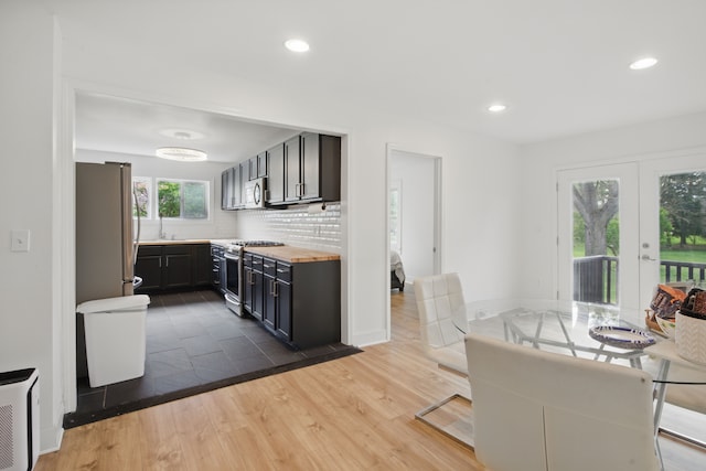 kitchen with wooden counters, appliances with stainless steel finishes, tasteful backsplash, recessed lighting, and dark wood-type flooring