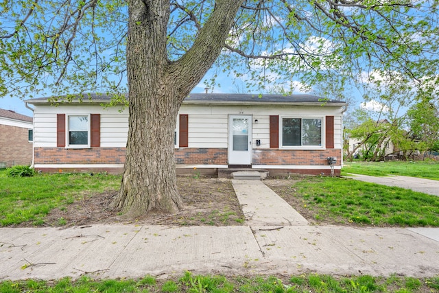 view of front of home featuring brick siding and a front yard