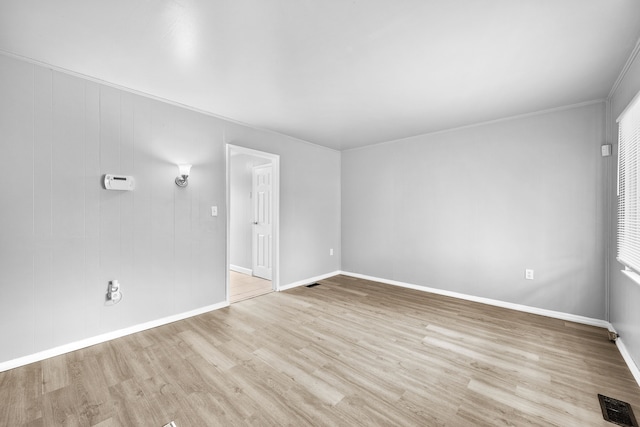 interior space featuring crown molding, baseboards, visible vents, and wood finished floors