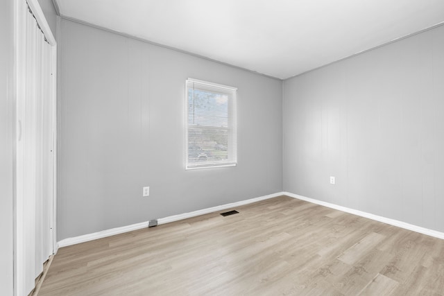 unfurnished bedroom featuring baseboards, a closet, light wood finished floors, and visible vents
