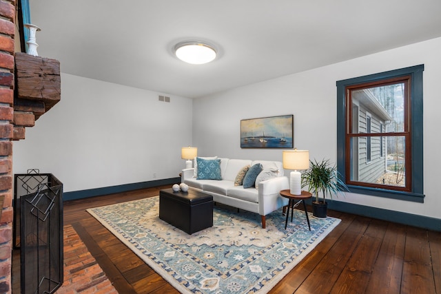 living area featuring baseboards, visible vents, and hardwood / wood-style floors