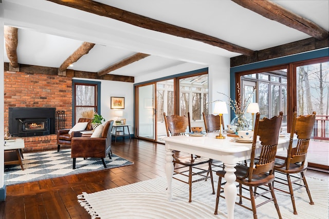 dining space featuring beamed ceiling, baseboards, hardwood / wood-style flooring, and a fireplace