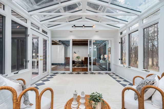 sunroom featuring french doors, lofted ceiling, and a wealth of natural light
