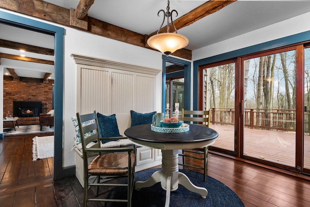 dining area featuring dark wood finished floors and beamed ceiling
