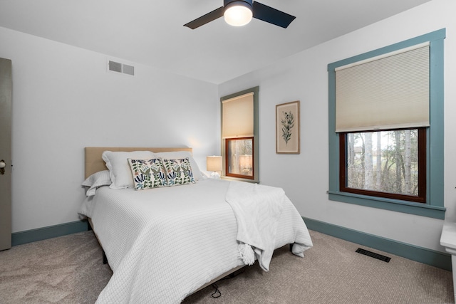 carpeted bedroom with baseboards, visible vents, and ceiling fan