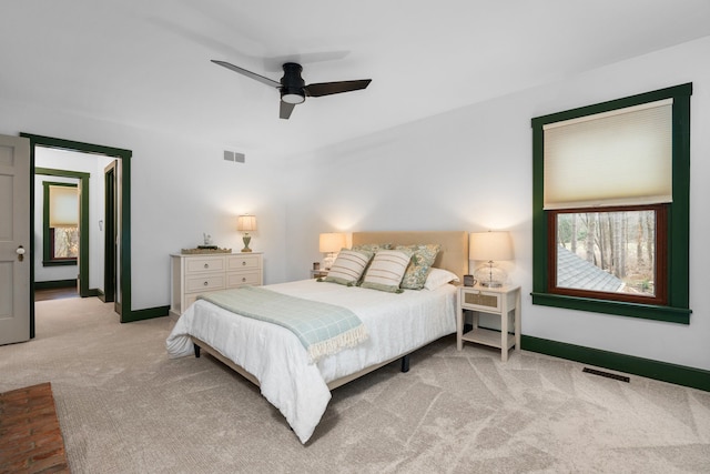 carpeted bedroom with visible vents, a ceiling fan, and baseboards
