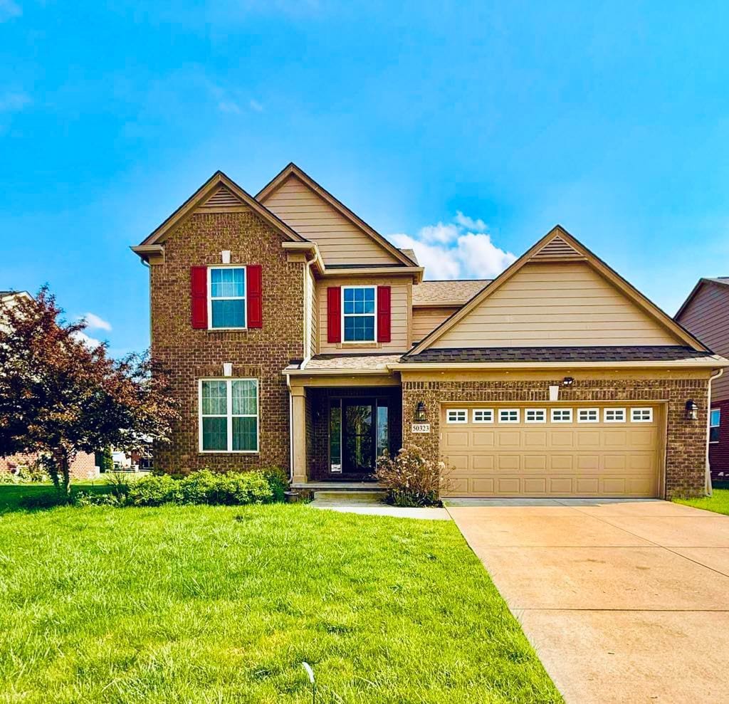 50323 Woodford Dr S, Canton, MI 48188 - view of front of home featuring brick siding, an attached garage, a front yard, driveway, and roof with shingles