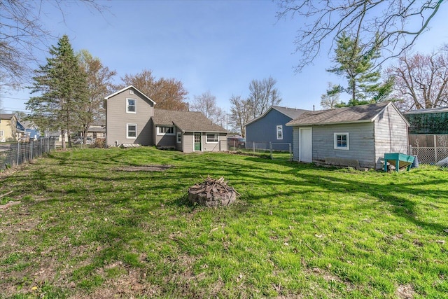view of yard featuring a fenced backyard, an outbuilding, and a fire pit