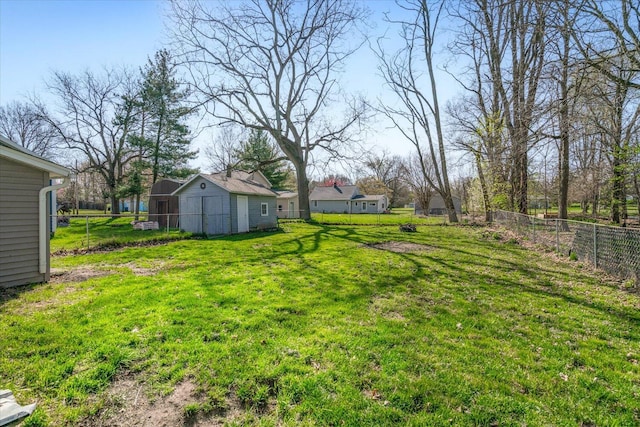 view of yard featuring a fenced backyard, an outbuilding, and a storage shed