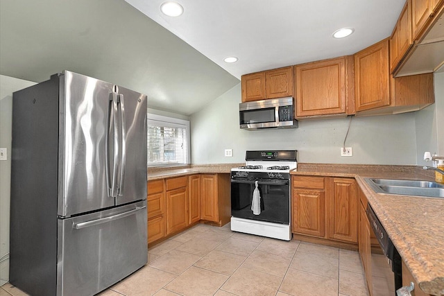 kitchen featuring lofted ceiling, recessed lighting, a sink, appliances with stainless steel finishes, and light tile patterned floors