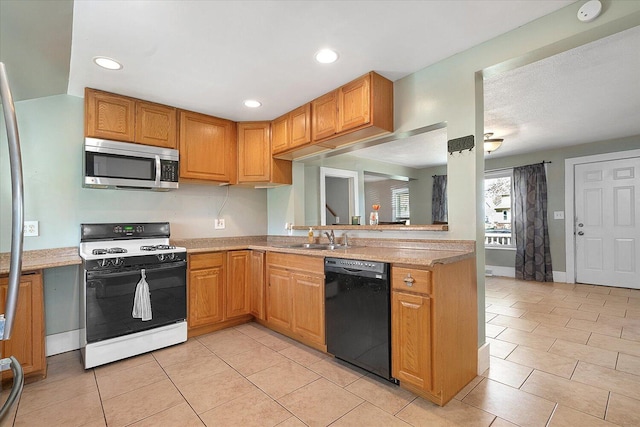 kitchen with light tile patterned flooring, a sink, gas stove, dishwasher, and stainless steel microwave