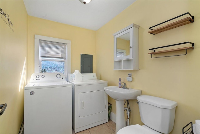 washroom with laundry area, washing machine and dryer, light tile patterned floors, and electric panel