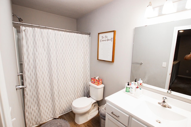 bathroom with toilet, curtained shower, wood finished floors, and vanity
