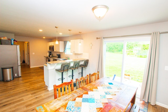 dining space with recessed lighting, baseboards, and light wood finished floors