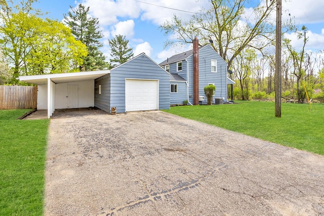 2408 Cobb Rd, Jackson, MI 49203 - garage featuring central AC unit, asphalt driveway, and a detached garage