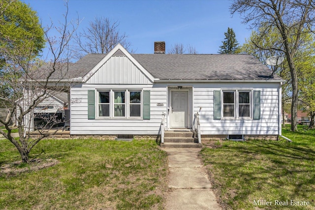 729 E Madison St, Hastings, MI 49058 - view of front facade with a shingled roof, a chimney, and a front lawn
