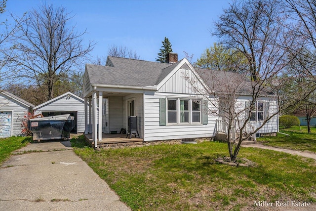 729 E Madison St, Hastings, MI 49058 - bungalow with covered porch, a front yard, a chimney, board and batten siding, and an outbuilding
