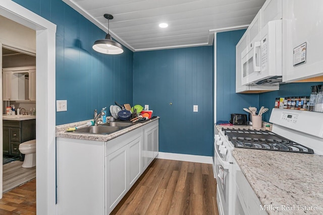 729 E Madison St, Hastings, MI 49058 - kitchen featuring white appliances, dark wood-style floors, white cabinets, a sink, and hanging light fixtures