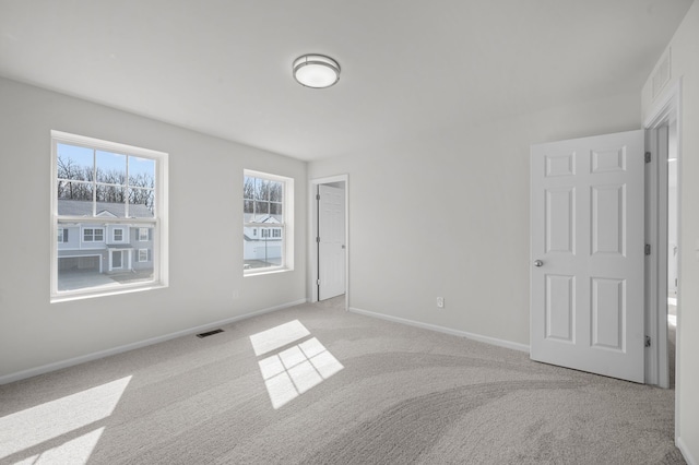 spare room featuring baseboards, carpet flooring, and visible vents