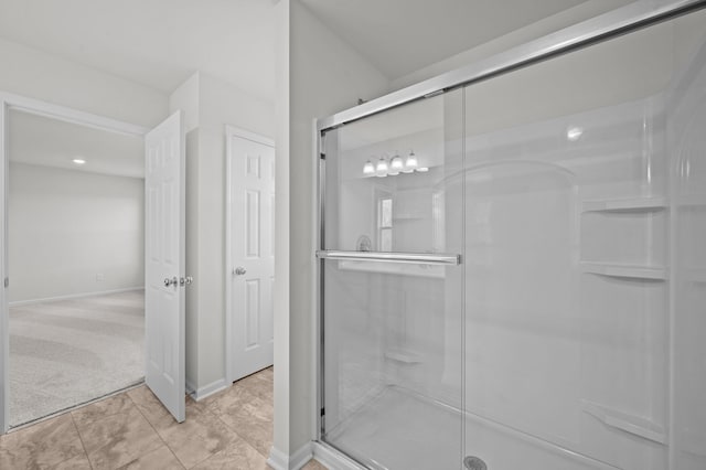 bathroom with baseboards and a stall shower