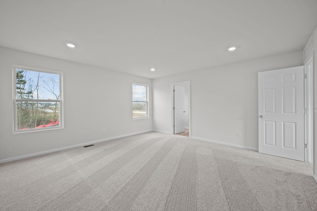 unfurnished room featuring plenty of natural light, light carpet, and recessed lighting