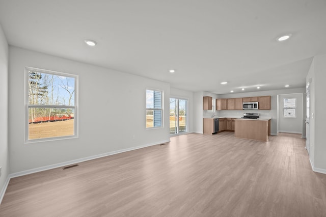 unfurnished living room with light wood-style floors, baseboards, recessed lighting, and visible vents