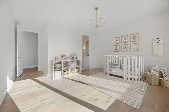 bedroom featuring a chandelier and wood finished floors