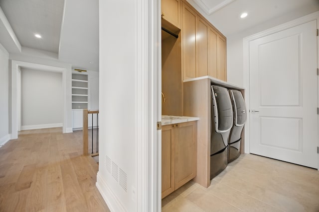 clothes washing area featuring recessed lighting, cabinet space, built in shelves, light wood finished floors, and baseboards