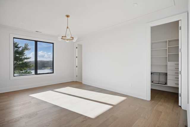 unfurnished dining area with light wood-type flooring, baseboards, and a chandelier