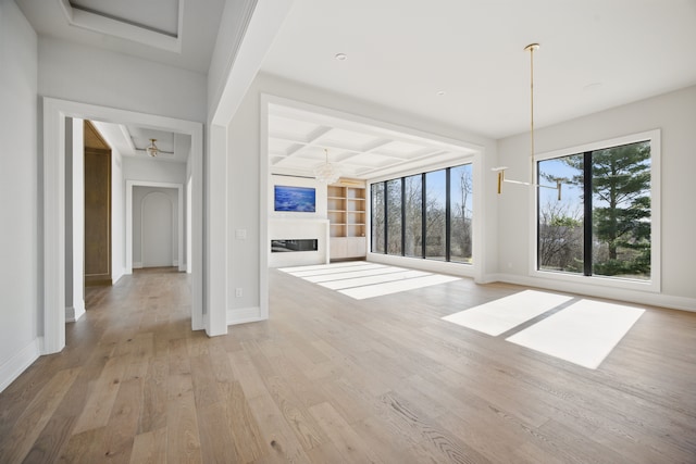 3281 Chickering Ln, Bloomfield Hills, MI 48302 - unfurnished living room featuring light wood-style floors, baseboards, a glass covered fireplace, coffered ceiling, and beamed ceiling