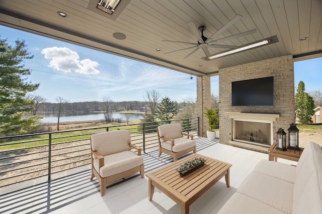 view of patio featuring an outdoor living space with a fireplace and a ceiling fan