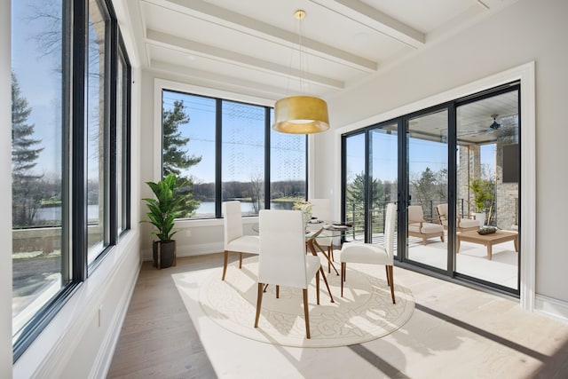 sunroom / solarium featuring beam ceiling, a water view, and french doors