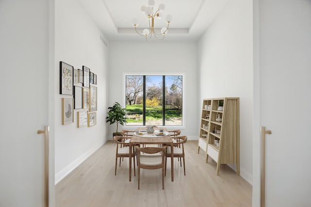 3281 Chickering Ln, Bloomfield Hills, MI 48302 - dining space featuring light wood-type flooring, a chandelier, a tray ceiling, and baseboards