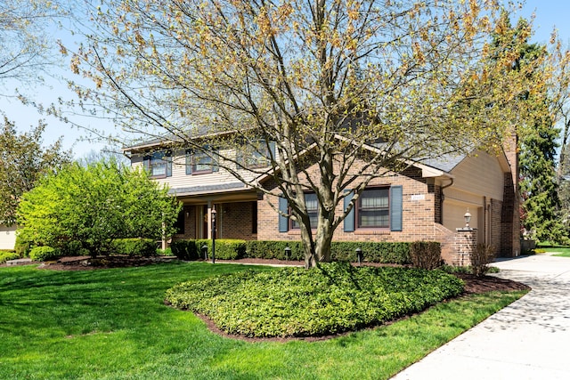 view of front of property featuring brick siding, driveway, a front lawn, and a garage