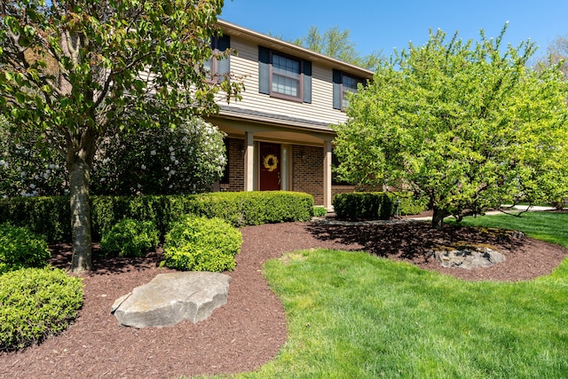 view of front of property featuring a front lawn and brick siding