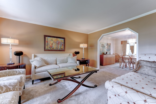 living room with baseboards, carpet flooring, an inviting chandelier, and ornamental molding