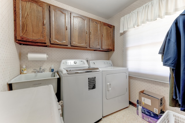 laundry area featuring a sink, cabinet space, washer and dryer, and wallpapered walls