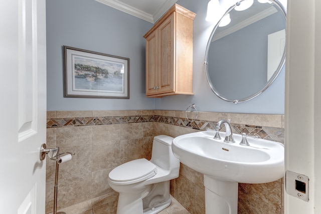 bathroom featuring crown molding, wainscoting, toilet, tile walls, and tile patterned floors