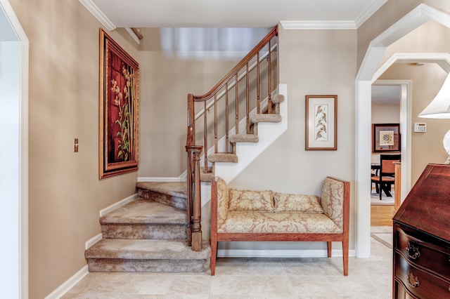stairs with crown molding and baseboards