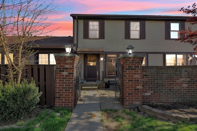 split level home with brick siding, fence, and entry steps