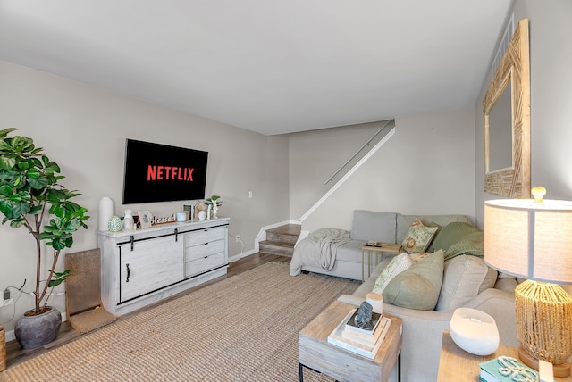 living area with stairway, baseboards, and wood finished floors