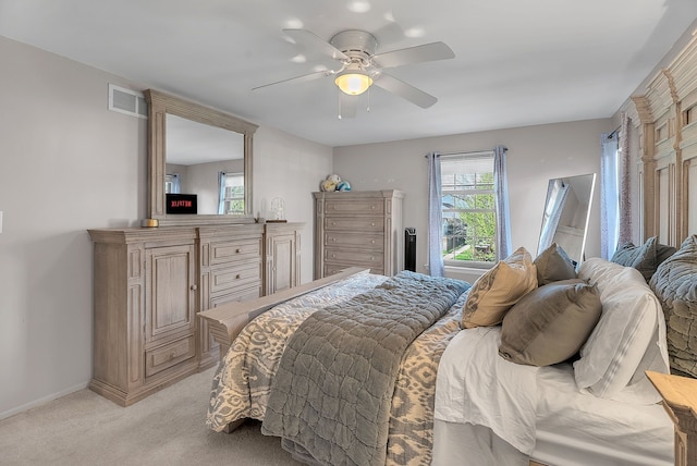 bedroom featuring visible vents, baseboards, ceiling fan, and light carpet