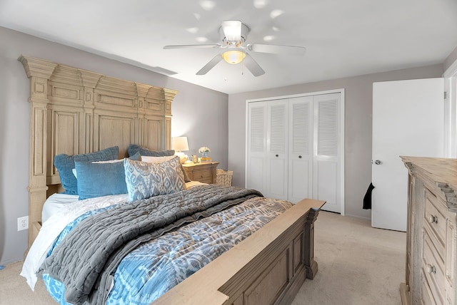 bedroom featuring light colored carpet, a ceiling fan, and a closet