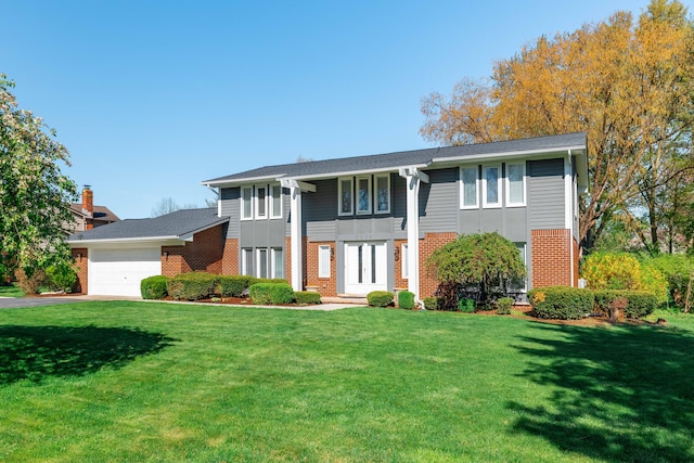 neoclassical / greek revival house featuring brick siding, a garage, a front lawn, and driveway
