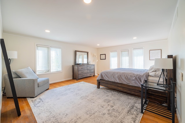 bedroom featuring baseboards, ornamental molding, light wood finished floors, and recessed lighting